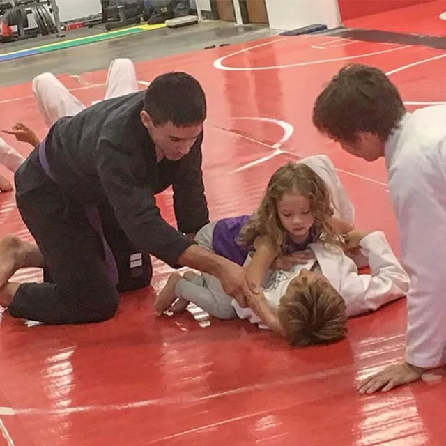 Kids practicing Brazilian Jiu-Jitsu together in a kids and family class at Aces Jiu Jitsu Club