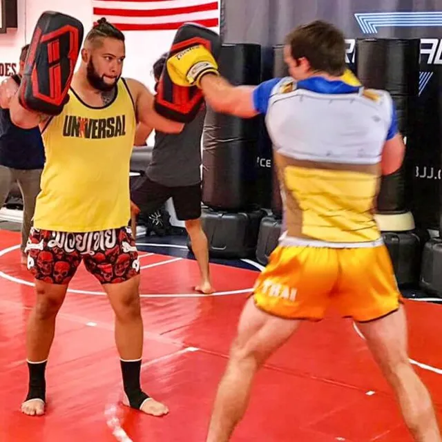 Students working Muay Thai pad drills in a striking class at Aces Jiu Jitsu Club